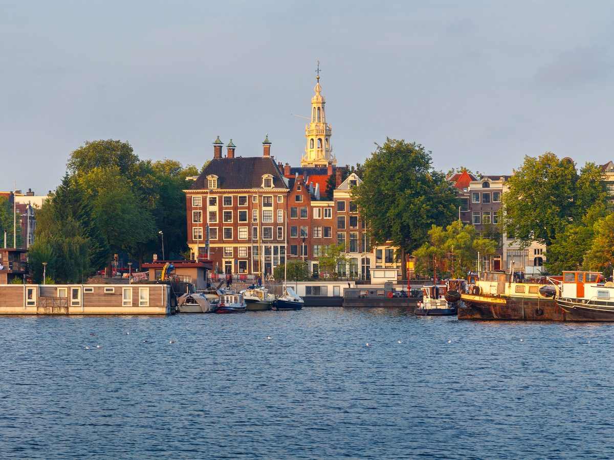 Historic canal houses reflected in the water in Amsterdam.